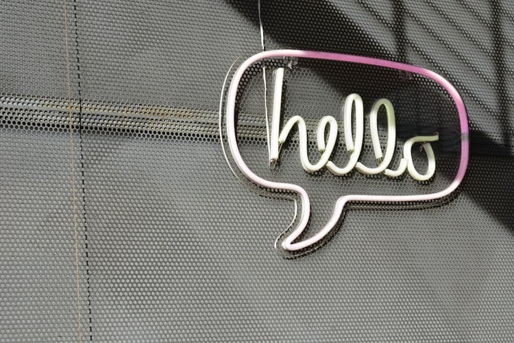 Fresh And Inspiring Summer Marketing Ideas virtual assistant blog. The image is a neon pink hello sign on a grated wall
